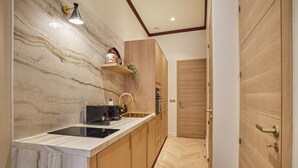 Una cucina moderna con schienale in marmo, mobili in legno e forno a incasso.