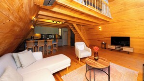 A cozy wooden interior with a sofa, a TV, and a dining area. - BEGONVİL GÜMÜŞLÜK  (Bodrum)