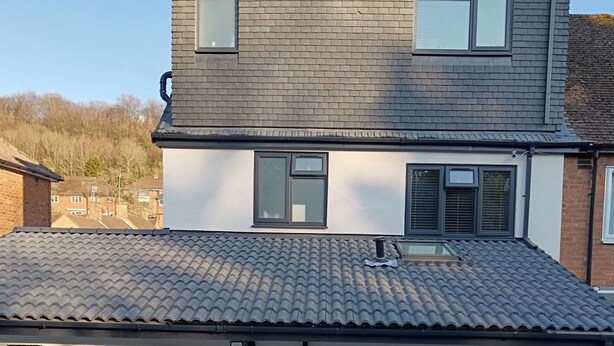 A two-story residential building with a tiled roof, a front door, and a small garden area. - High Wycombe 1-bed Apt, Sleeps 3 & Private Parking (High Wycombe)