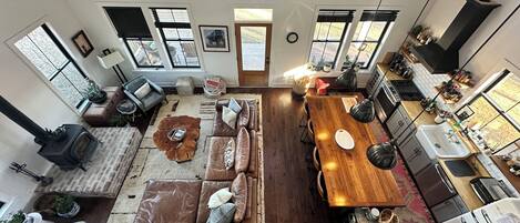 A spacious living area with a large wooden dining table, leather sofas, and a cozy fireplace.
