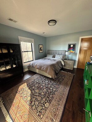 A bedroom with a bed, a nightstand, a dresser, a window, and a door. - Farmhouse Getaway - Firepit, Views & Stargazing (Castleton)