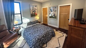 A bedroom with a bed, a desk, a chair, a ceiling fan, and two doors. - Farmhouse Getaway - Firepit, Views & Stargazing (Castleton)