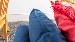 Een kamer met een flatscreen-televisie aan de muur, waarop een Netflix-omgeving wordt getoond.