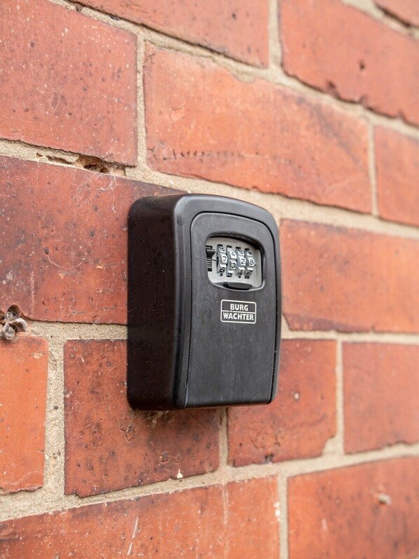 A black intercom mounted on a brick wall.