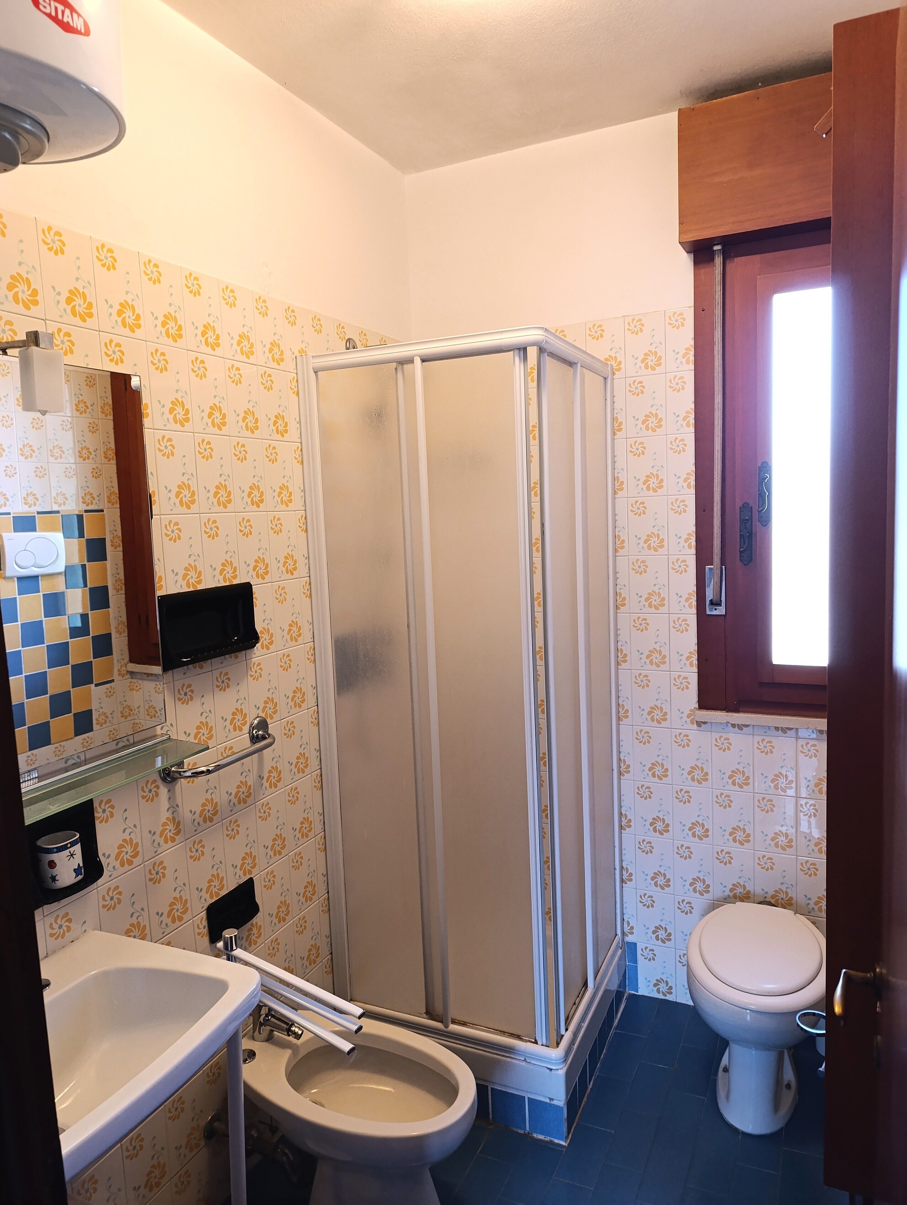 Un baño con cabina de ducha, inodoro, lavabo y espejo.