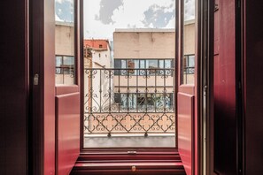 A view from a balcony with wrought iron railings and a red door. - Libertad 24 (Madrid)