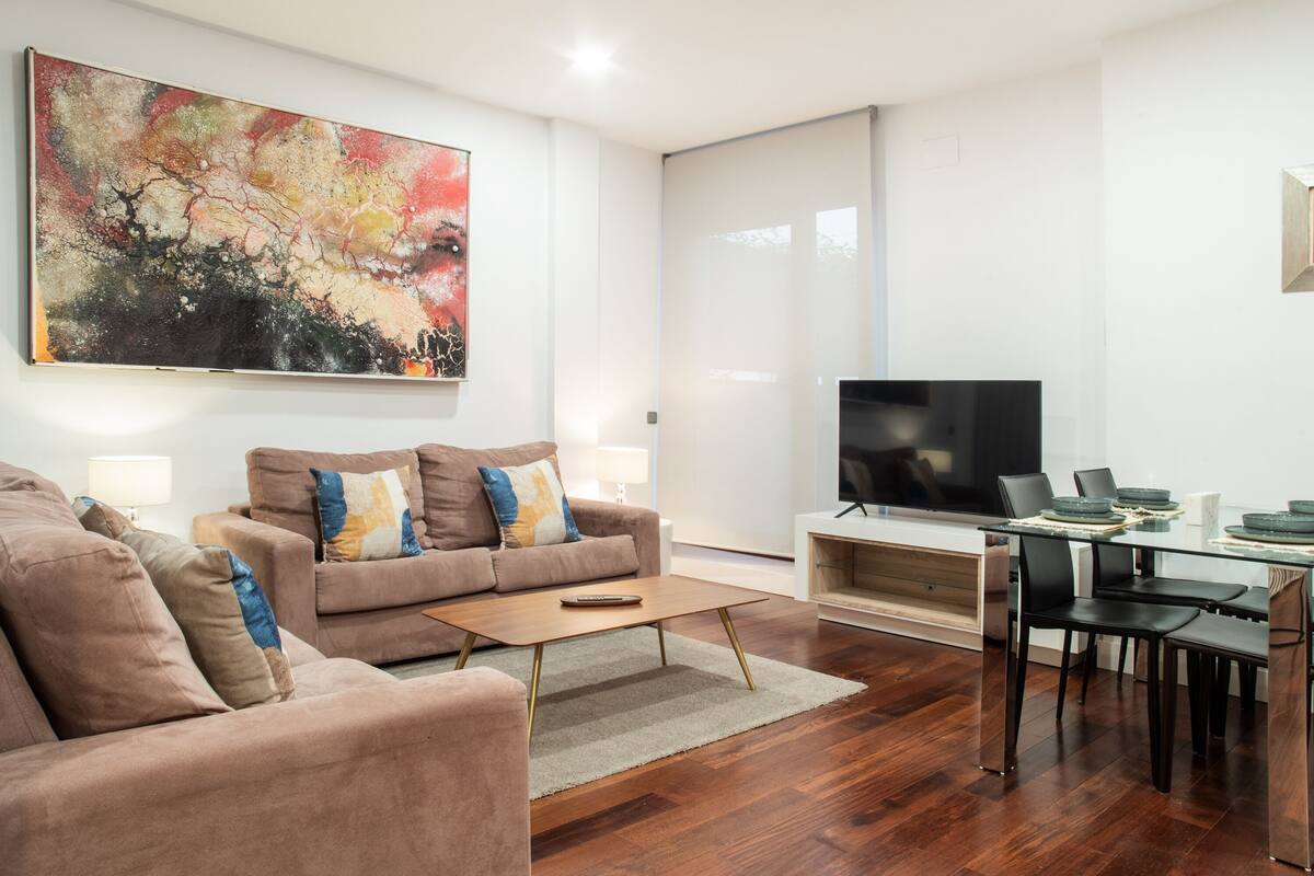 A modern living room with a sofa, coffee table, and a TV.