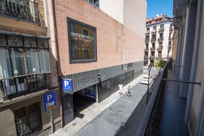 A street view with a building featuring a large window and a sign for "El Bar de San Anton". - Libertad 24 (Madrid)