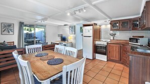 Une cuisine compacte avec des meubles en bois, un four encastré et un four à micro-ondes.