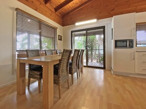 Enjoy meals at the dining table with six chairs, and access to an outdoor area through the sliding glass door.