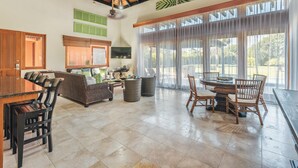 A spacious living area with a dining table, chairs, a sofa, and a ceiling fan. - Bungallow Private Pool 4 Guests Cap Cana (Punta Cana)