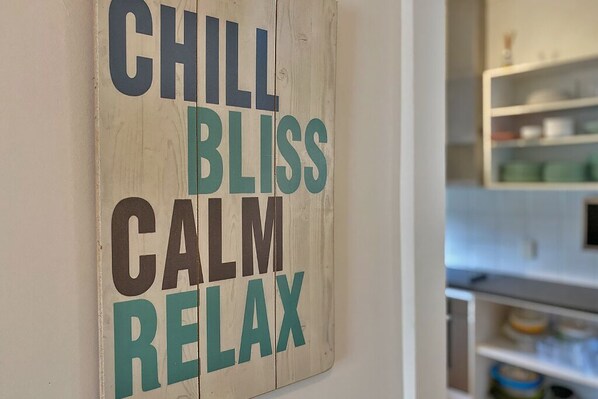 Un letrero de madera con las palabras 'CHILL BLISS CALM RELAX'.
