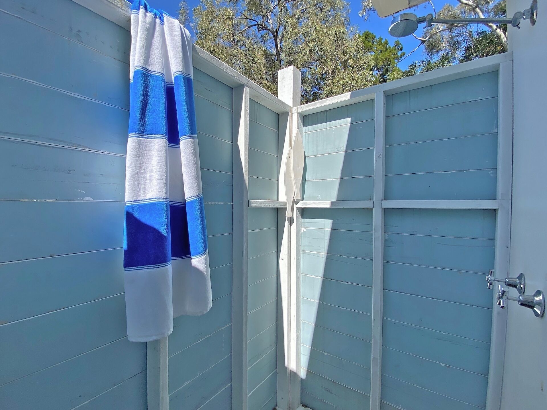 Une porte en bois bleue avec une serviette blanche qui y est accrochée.