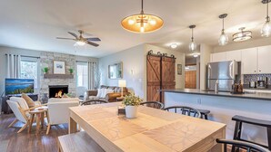 A modern kitchen with a large island, built-in appliances, and a stone fireplace. - ✓ King Bed+  ✓ Sleeps 8 ✓ Walk to Downtown + Coaster ✓ Ground Floor (Leavenworth)