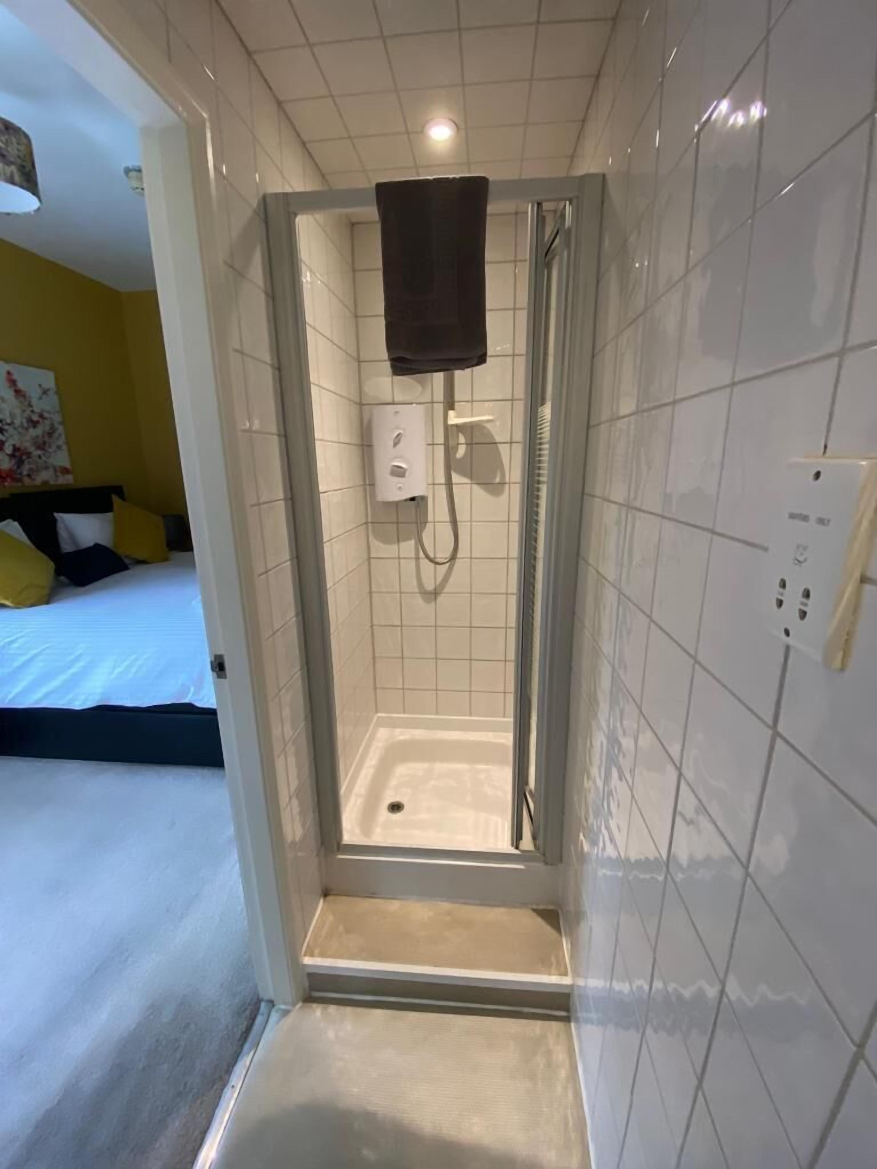 Habitación con 2 camas individuales | Baño | Regadera, secadora de cabello, toallas, papel de baño 