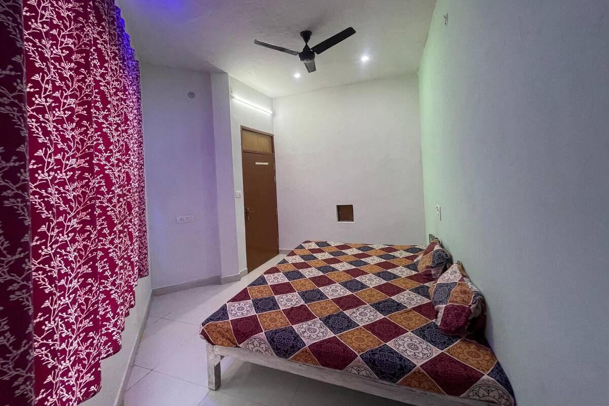 Un dormitorio con cama, ventilador de techo y una puerta.