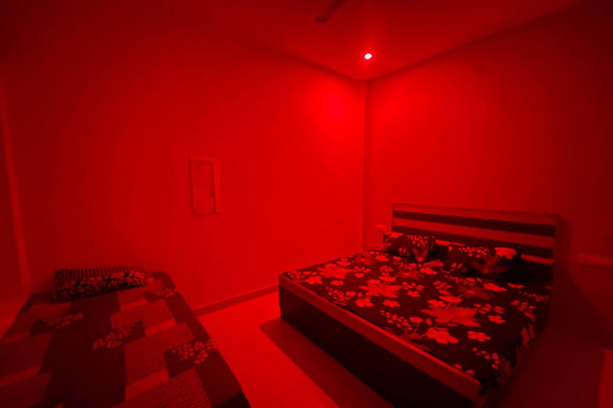 Un dormitorio con cama, mesita de noche y escritorio.