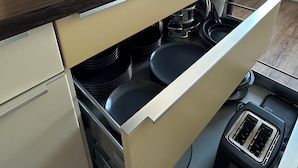 A compact kitchen with a built-in stove, a kettle, and a coffee maker. - HARMONY "4" 1-room apartment with kitchen (Gütersloh)