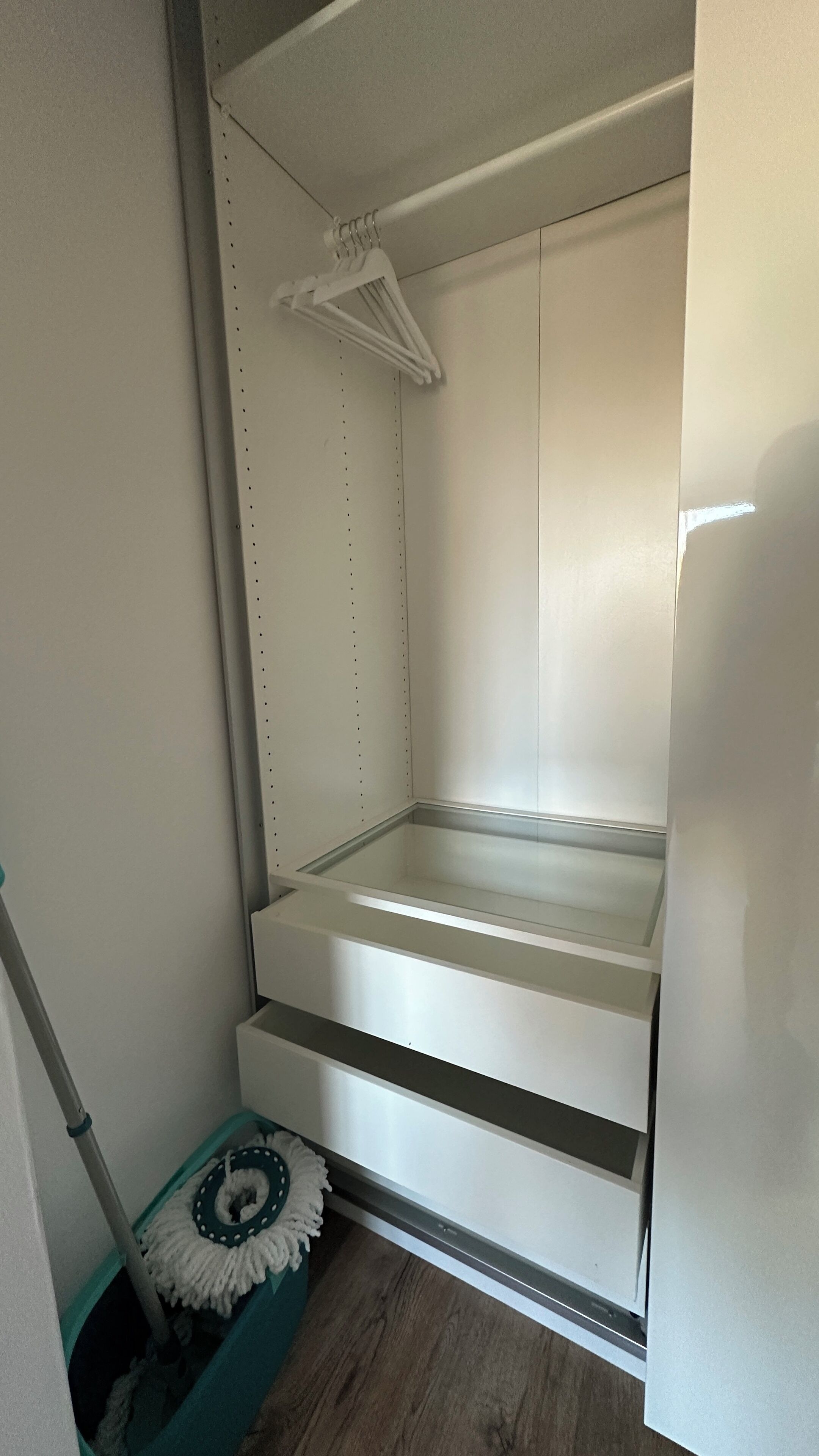 Une petite pièce étroite, dotée d’un banc intégré et d’un portant à vêtements suspendu.