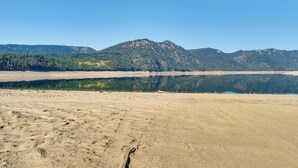 Un paisaje amplio y abierto con una gran masa de agua que refleja las montañas circundantes.