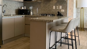 A modern kitchen with a central island, bar stools, and pendant lighting. - Breakfast Included Regatta Living II 404 (Santo Domingo)
