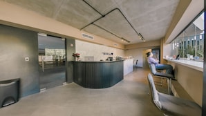 A modern kitchen with a marble countertop, a refrigerator, and a seating area with a window view. - Breakfast Included Regatta Living II 404 (Santo Domingo)