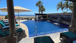 A pool area with lounge chairs, a water feature, and a view of the ocean. - Novaispania Estates Governor (Cabo San Lucas)