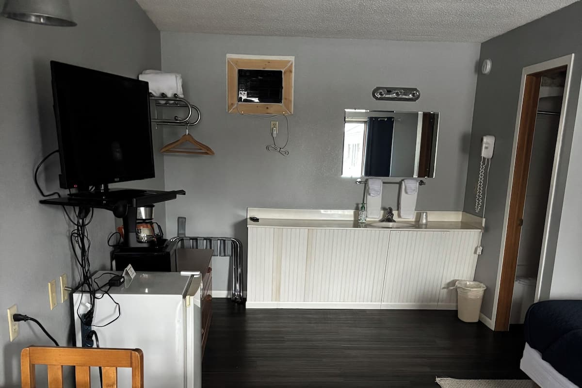A compact living space with a dining area, kitchenette, and a small bathroom.