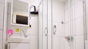 A modern bathroom with a glass shower enclosure, a white sink, and a toilet. - Polo Suit Otel (Istanbul)
