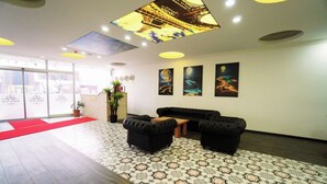 A lobby with a reception desk, black sofas, patterned flooring, and artwork on the walls. - Polo Suit Otel (Istanbul)
