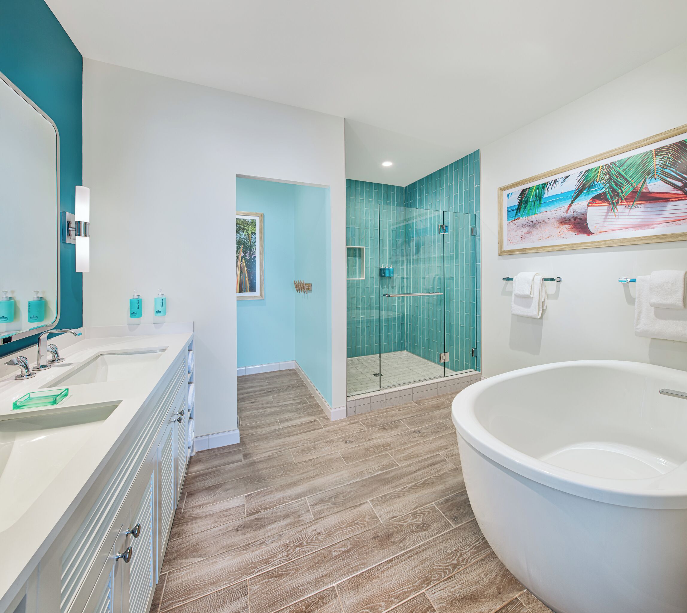 A modern bathroom with two sinks, a large bathtub, and a glass-enclosed shower.