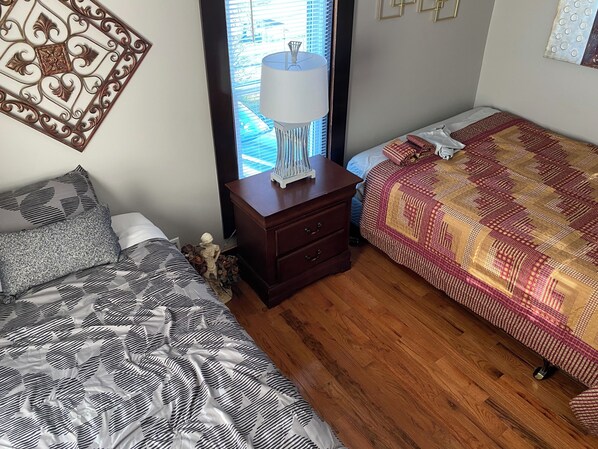 A bedroom with a bed on the left, a nightstand with a lamp, and a window with blinds. - 2-bedroom with a loft . Only a block away from the ATV/hiking trails !!! (LaFollette)