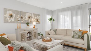Relax in this inviting living room with a comfortable sofa set, coffee table, and large window.