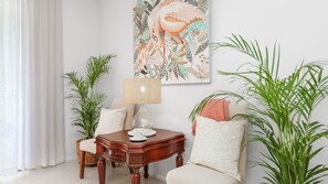 Relax in this stylish living room with a comfortable sofa, wooden coffee table, and vibrant artwork.