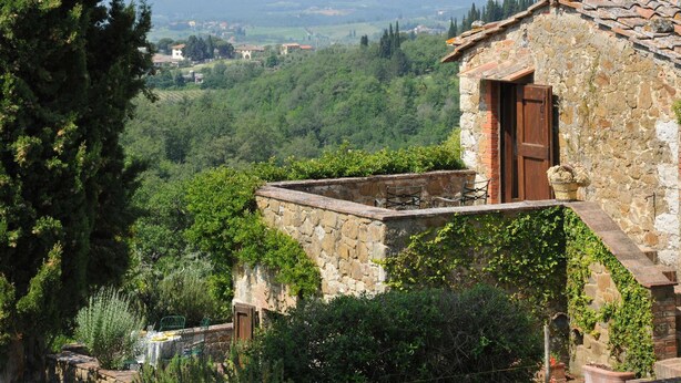 A stone building with a wooden door, surrounded by greenery and overlooking a valley. - Stunning villa with large pool in the heart of Chianti 12km from Siena (Radda in Chianti)