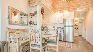 Een gezellige keuken met een houten eettafel, witte stoelen en een inbouwoven.