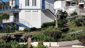 Ein zweistöckiges Gebäude mit blauem Dach, weißen Wänden und einem Balkon.
