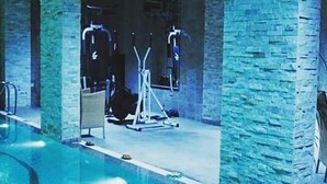 Une piscine avec un mur en pierre et du matériel d’exercice.