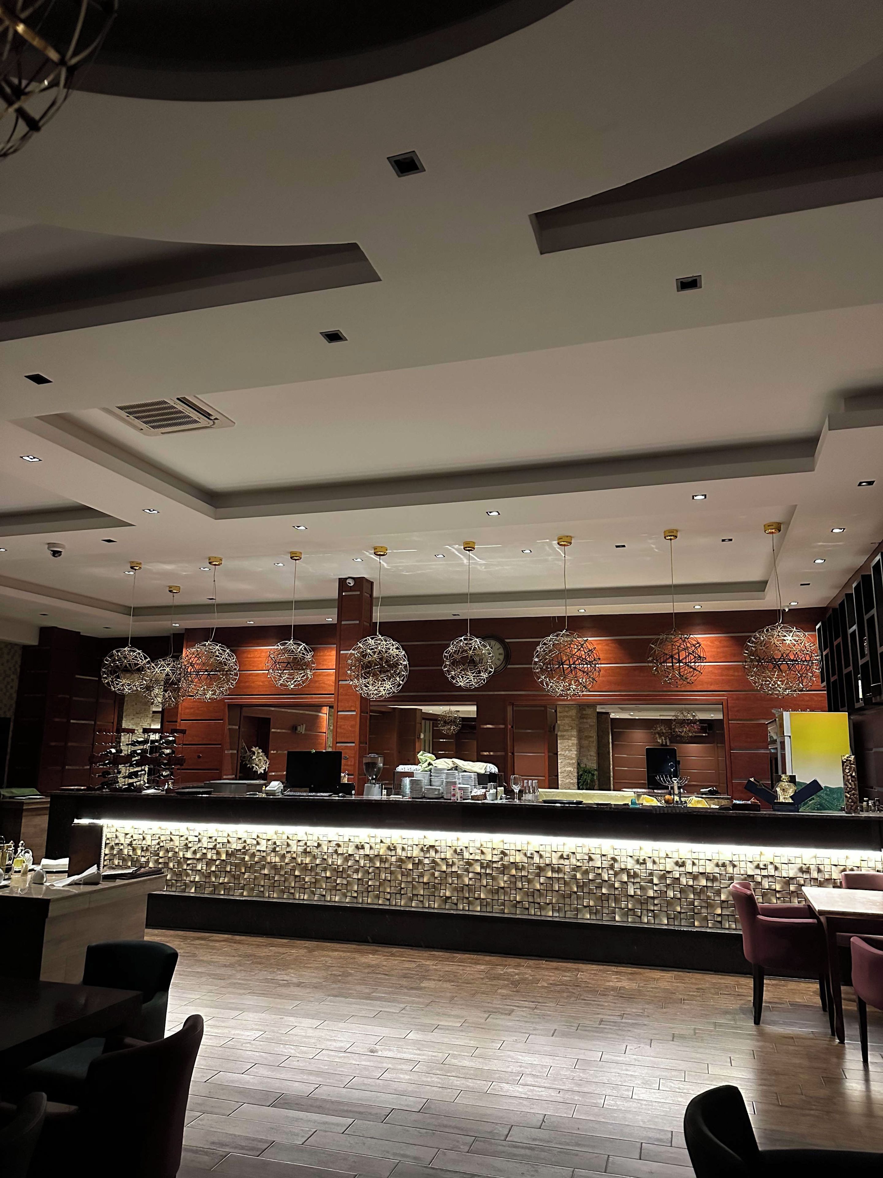 A modern interior with a reception desk, seating area, and decorative lighting.
