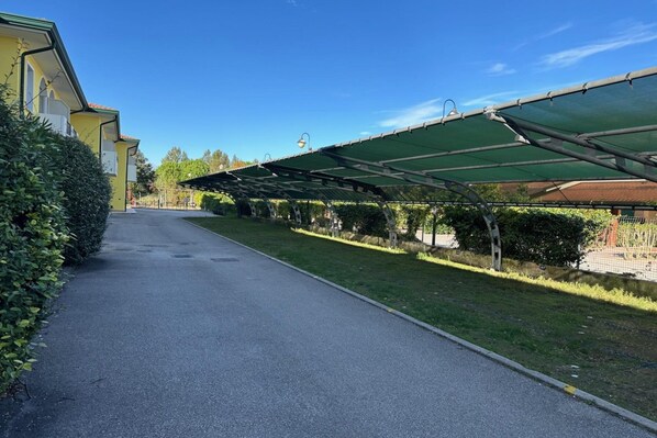 Un camino que lleva a un edificio con un espacio al aire libre techado.