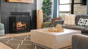 A modern living room with a fireplace, a sofa set, and a coffee table.