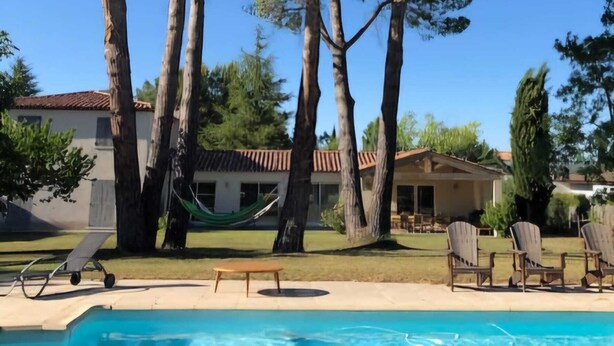 A pool with lounge chairs and a hammock, surrounded by trees and a building with a tiled roof. - 5 kms from Aix en Provence (Puyricard) 4-bedroom villa swimming pool garden 2000 m2 (Aix-en-Provence)