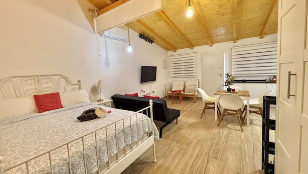 Un dormitorio con cama, escritorio, silla y televisor.