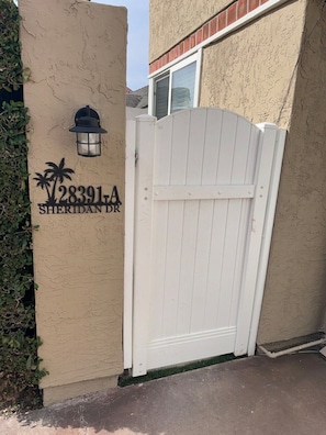 A gated entrance with a sign reading "28391A SHERIDAN DR" and a decorative lamp. - Studio in QUIET  SFR home, gated community. (Laguna Niguel)