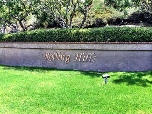 A sign reading "Rolling Hills" on a concrete wall with a grassy area in front. - Studio in QUIET  SFR home, gated community. (Laguna Niguel)