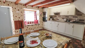 A dining area with a table set for two, a bottle of wine, and plates with food.