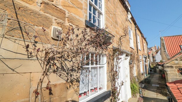 A stone building with a window and a small balcony.
