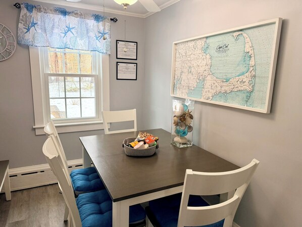 Un comedor con una mesa, sillas, una cesta decorativa y un mapa mural.
