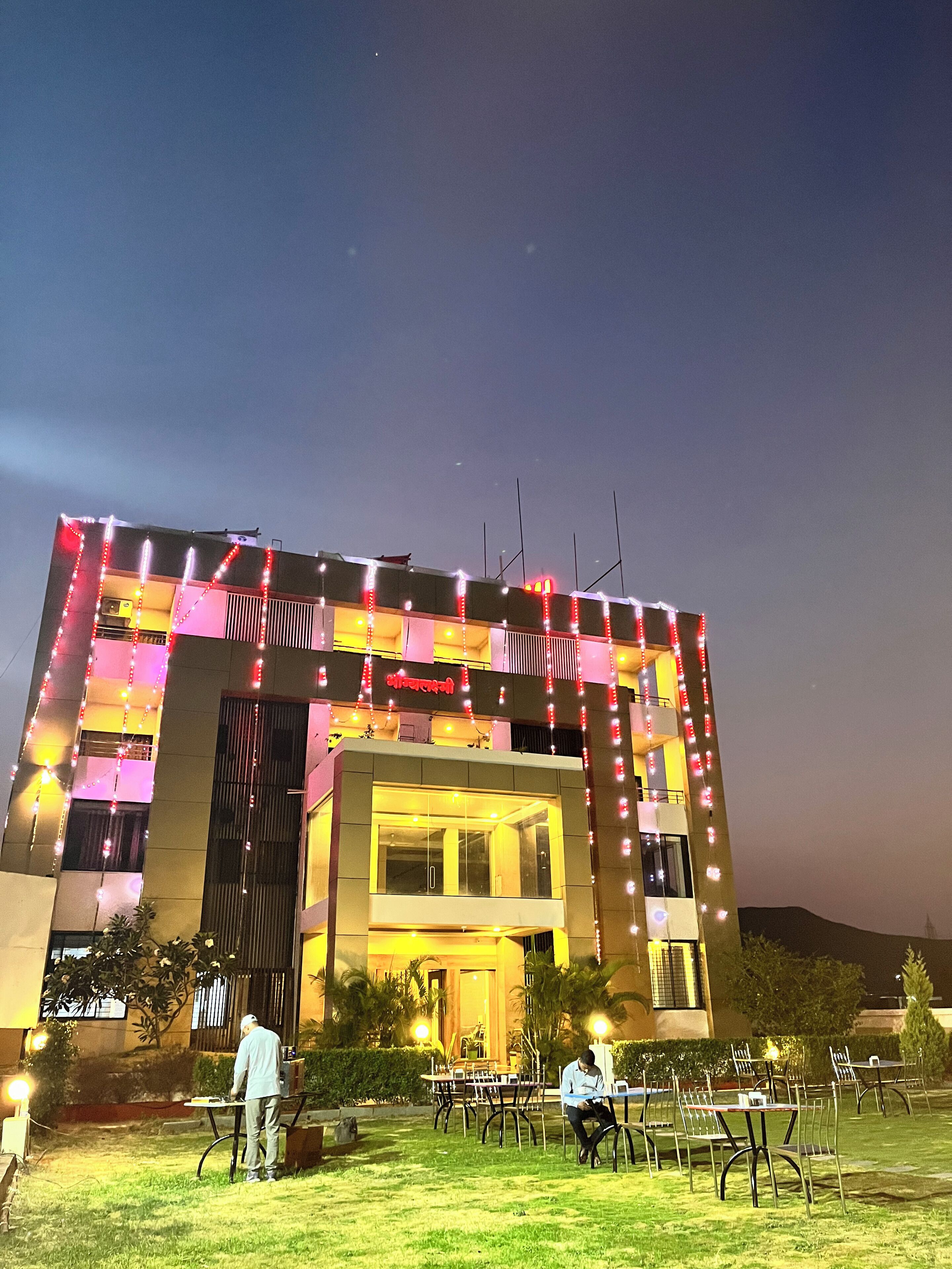 Un edificio con diseño arquitectónico moderno, que destaca por su entrada principal y una serie de luces a lo largo de la fachada.