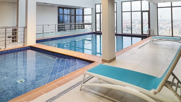 Ein Innenpool mit freiem Blick auf die Stadt durch große Fenster.